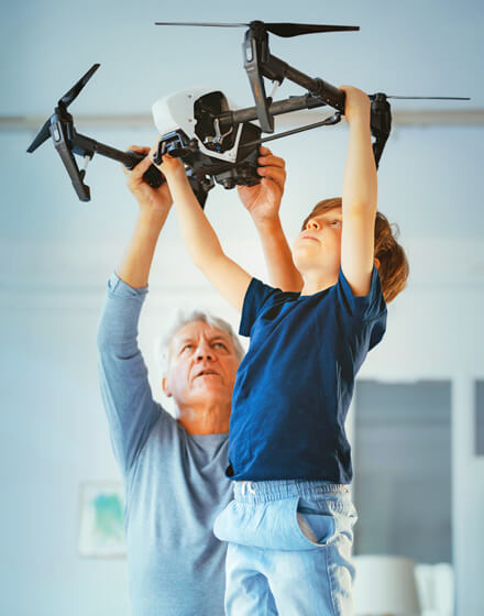 man helping small boy hold drone