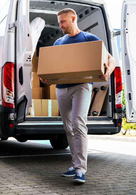 man moving cardboard box out of van