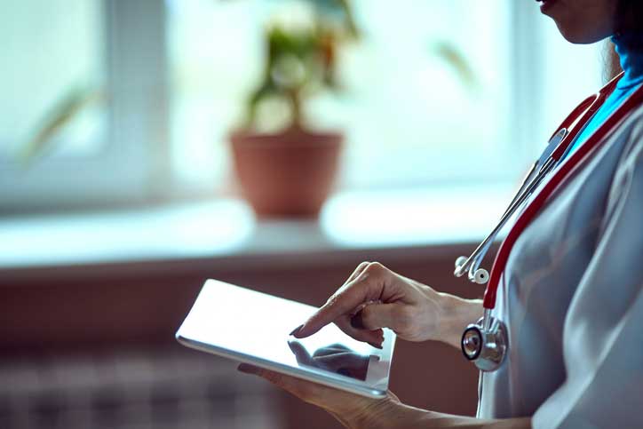 Doctor working on a digital tablet with copy space