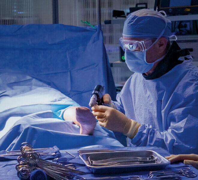 Surgeon performing orthopedic surgery on foot