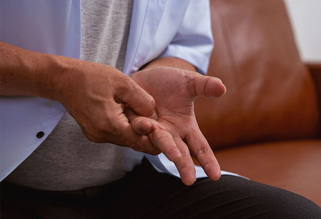 Male patient suffering from numbing pain in hands from flexor tendonitis; concept of joint pain and rheumatoid arthritis