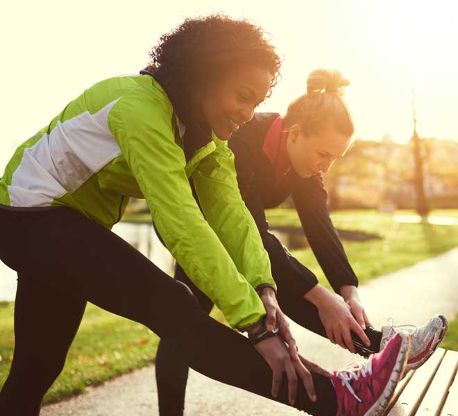 two women stretching in a park